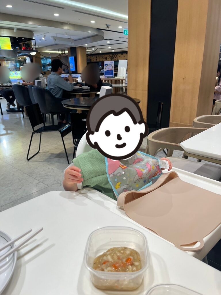 子ども椅子で食事をする息子の写真。