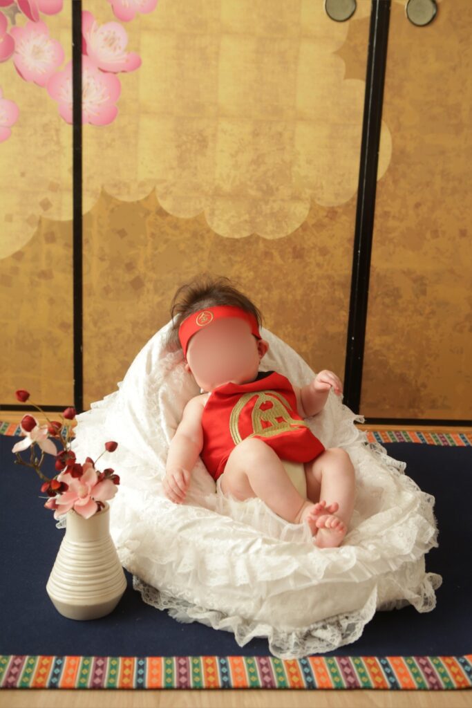 金太郎の衣装を着て撮影する息子の写真。