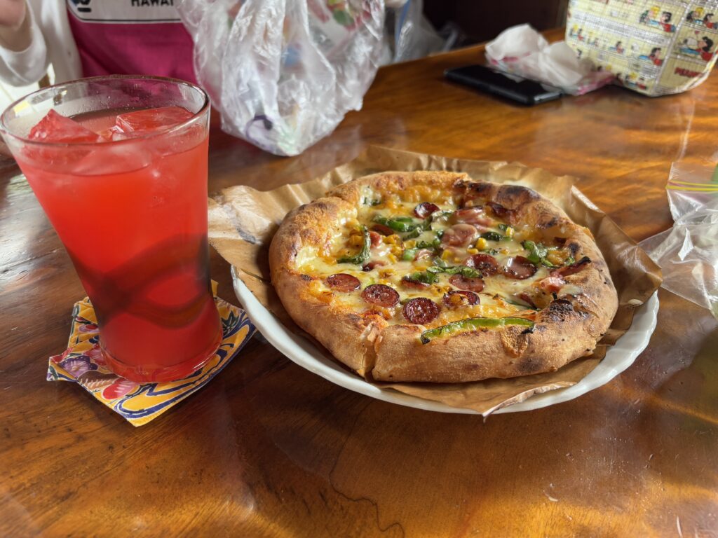 ピザとアセロラジュースの写真。