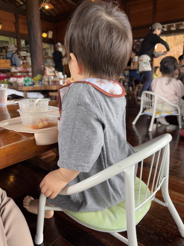 子ども椅子を使って食事する息子の写真。